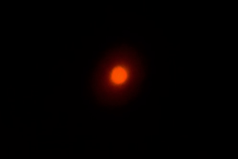 A burry image of a solar eclipse taken from eclipse glasses against a phone’s camera