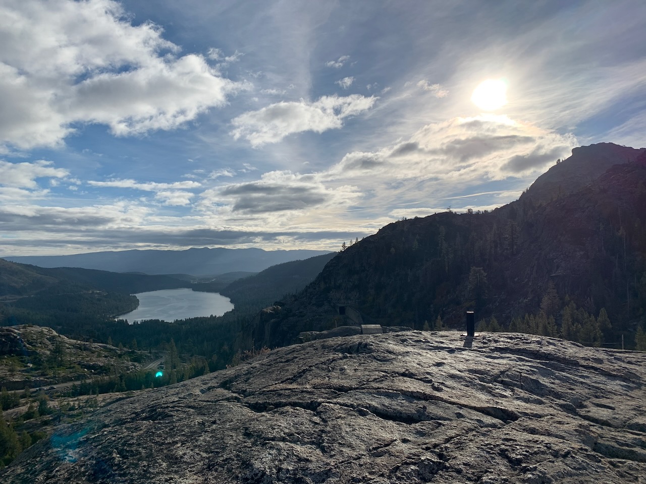 A view from a mountain with a partial sun in the reflection