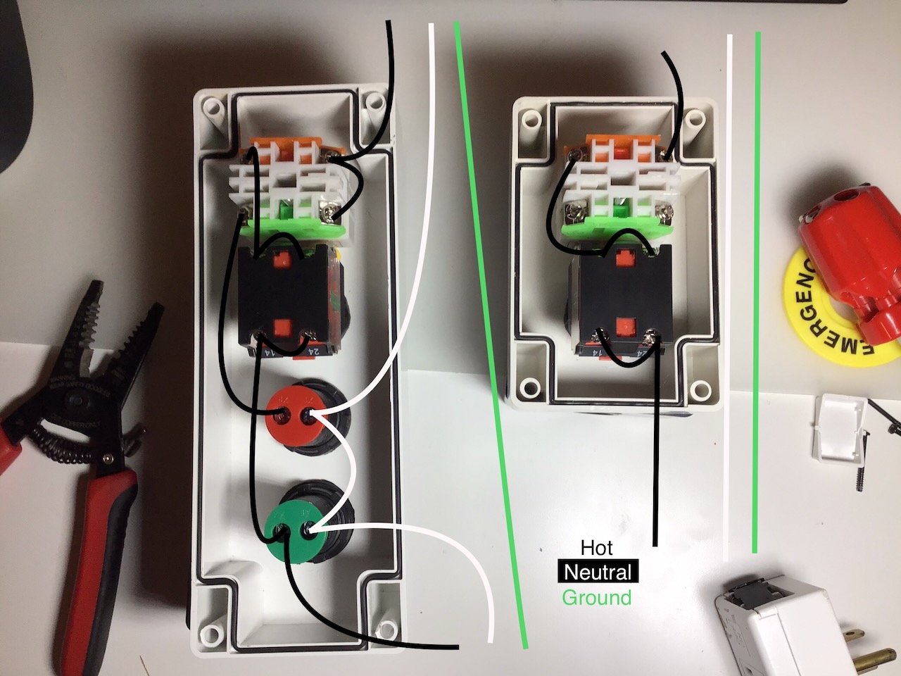 Two casings with the parts for an emergency stop button, complete with wiring.